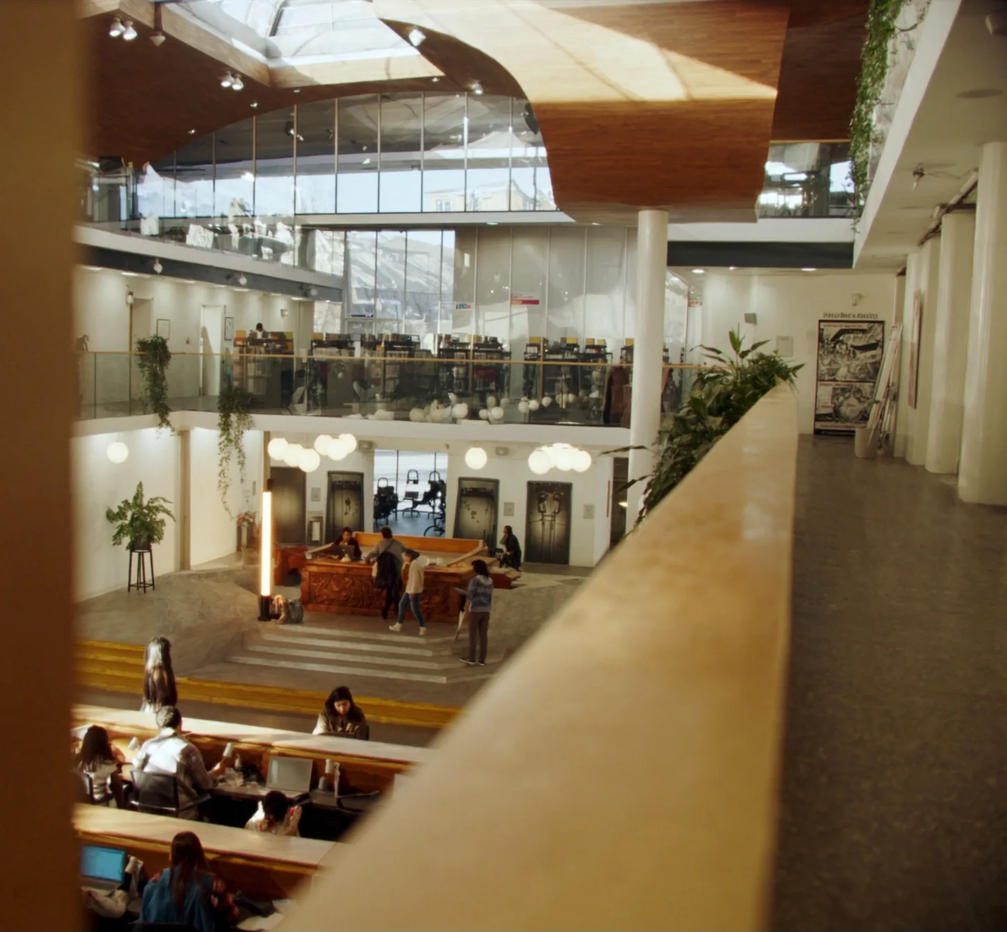 Students working in a university library atrium